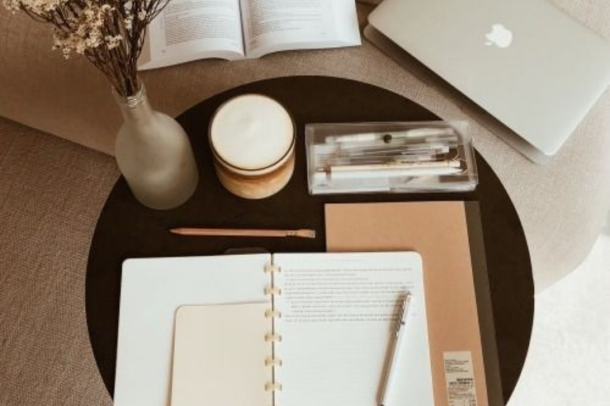 note pad and pen and computer on side table
