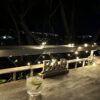 Gin and tonic on a balcony table with fairy lights and city lights in the distance.